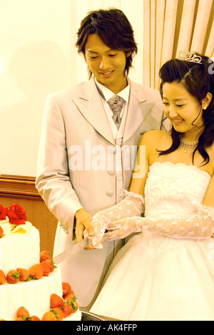 Newlywed couple cutting the wedding cake Stock Photo