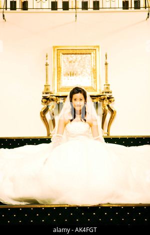 Portrait of bride sitting on staircase Stock Photo