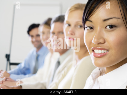 Group of exectives, sitting in a row, focus on foreground Stock Photo