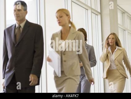 Group of business executives walking through corridor Stock Photo