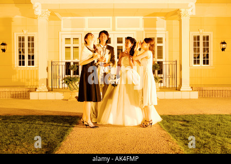 Newlywed couple relaxing in the courtyard with guests Stock Photo