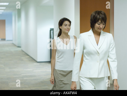 Businesswoman and assistant walking through corridor Stock Photo