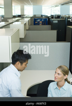 Two office workers talking in cubicle Stock Photo
