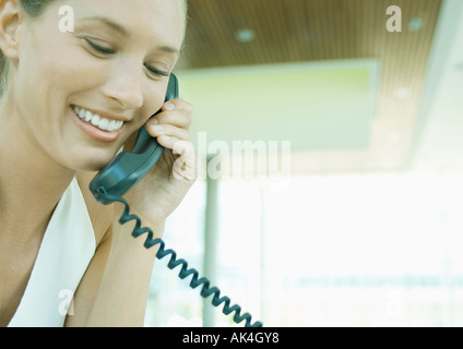 Woman using landline phone Stock Photo