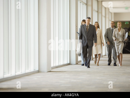 Executives walking through corridor of office building Stock Photo