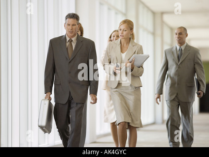 Executives walking through corridor of office building Stock Photo