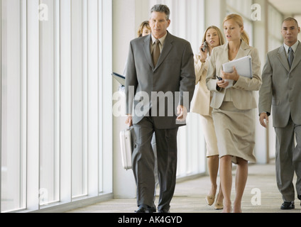 Executives walking through corridor of office building Stock Photo