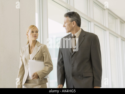 Executives walking through corridor of office building Stock Photo
