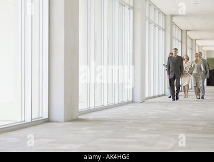 Executives walking through corridor of office building Stock Photo