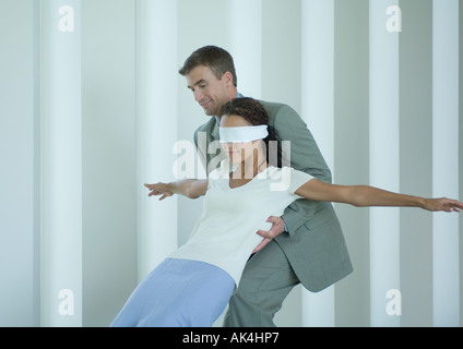 Businessman catching blindfolded woman Stock Photo