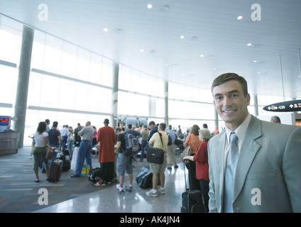 Businessman standing in airport boarding area Stock Photo