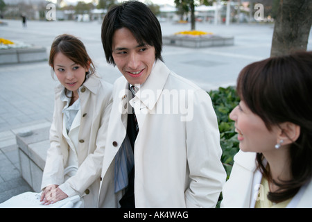 Businessman and two women sitting in park Stock Photo