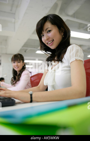 Two female office workers using computers Stock Photo