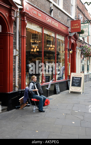 Accordion player outside french cafe in York Stock Photo