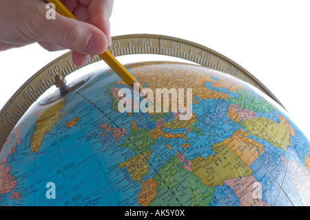 woman's hand pointing pencil at Europe on globe in classroom Stock Photo