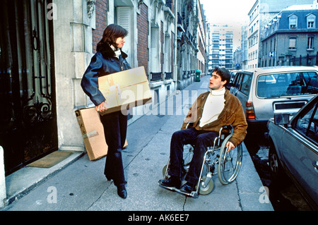 Paris, France, Handicapped man, Wheelchair on Street, Speaking with a Woman Friend, Helping Him to Move in, special needs, friends in the street Stock Photo