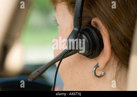 young woman talking on cell phone headset in car Stock Photo