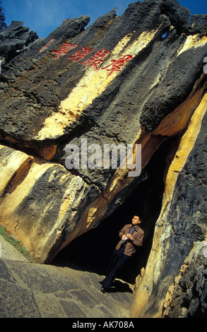 Chinese Man Walking Through Narrow Passageway in the Stone Forest in the Province of Yunnan Stock Photo