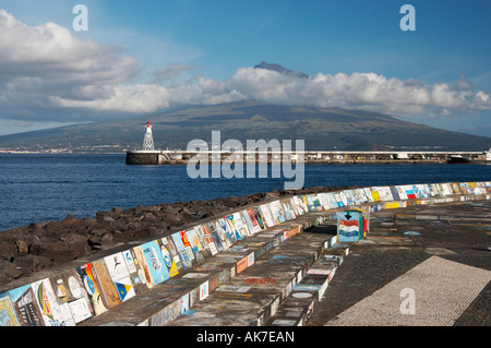 Horta marina wall on Faial island in The Azores with the island of Pico in the distance Stock Photo