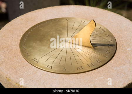 Brass sundial mounted on a stone plinth Stock Photo