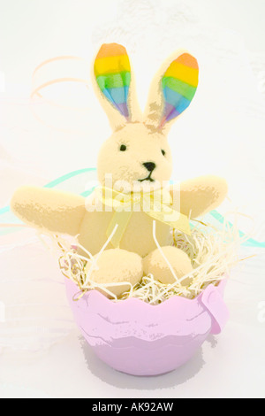 Toy Easter bunny sitting in an egg nest Stock Photo