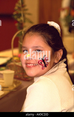 American Indian girl age 12 smiling with butterfly face paint at Exchange Charities Easter dinner. Minneapolis Minnesota USA Stock Photo