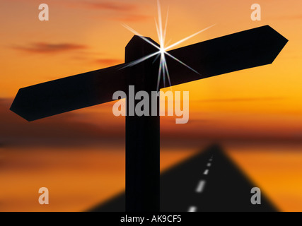 road signpost silhouetted in sunset with road to distant horizon Stock Photo