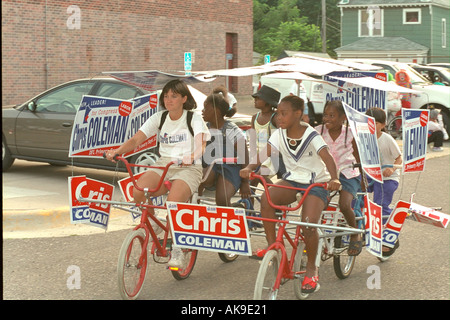 Political campaigners age 12 and 28 riding bikes in the Frogtown Parade and Festival. St Paul Minnesota USA Stock Photo