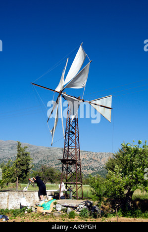 A couple washing their laundry beside a windmill on Lasithi Plateau in eastern Crete Greece Stock Photo