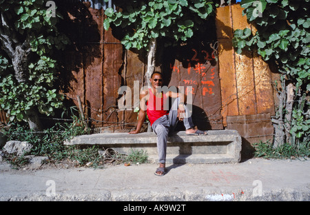 Young man sitting on a bench in the La Corea barrio on the outskirts of Havana Cuba Stock Photo
