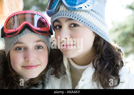Two young friends wearing knit hats and ski goggles, smiling at camera, portrait Stock Photo