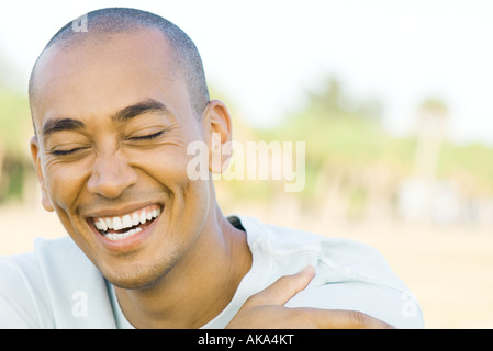 Man with shaved head, laughing, eyes closed, portrait Stock Photo