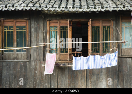 China, Guangdong Province, laundry hanging in front of wooden house Stock Photo