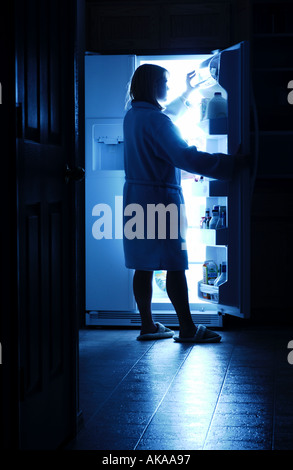 Woman opening refrigerator for a midnight snack Stock Photo