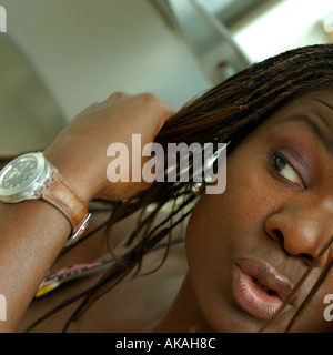 Black woman with a watch doing her hair full lips Stock Photo