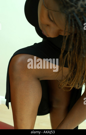 Black Woman looking down as she does up her shoes Stock Photo