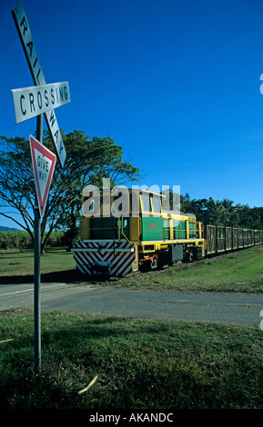 Railway crossing and sign with train carrying sugar can on the Sugar Cane Railway in Queensland Australia Stock Photo