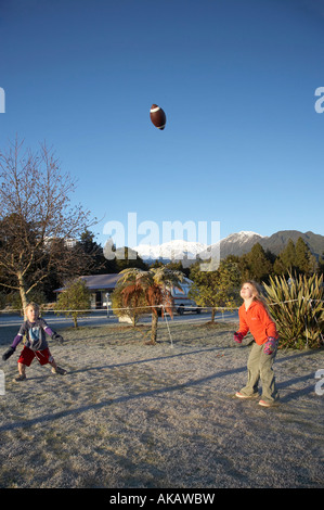 Children Playing Rugby in the Frost Frans Josef Glacier Campground West Coast South Island New Zealand Stock Photo