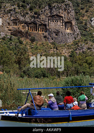 Tourists in boat looking at Lycian rock tombs on the Dalyan river Turkey Stock Photo