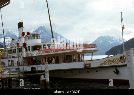 Visitors aboard ocean vessel view majestic blue mountains in the distance beyond the cruise ship before leaving this Alaska Port Stock Photo