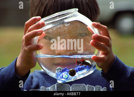 Boy holding fishbowl in front of face Stock Photo