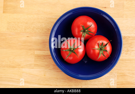 Three tomatoes in a bowl Stock Photo