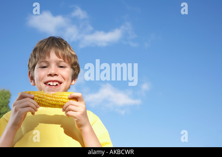 Portrait of boy (7-9) eating corn on the cob Stock Photo