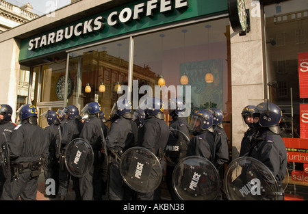 Riot police in full uniform assembled outside a branch of Starbucks Cafe ahead of anti-globalization protest Edinburgh Stock Photo