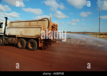 Water truck spraying to suppress dust on coal mining site access road ...