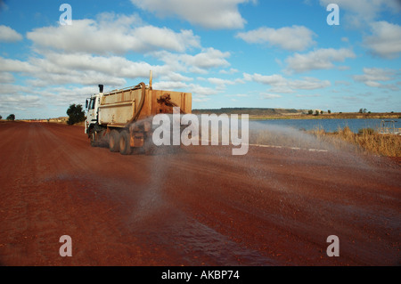Water truck spraying to suppress dust on coal mining site access road ...