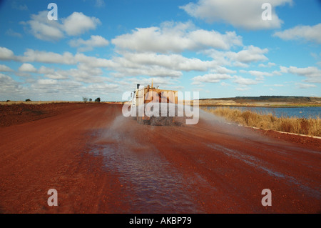 Water truck spraying to suppress dust on coal mining site access road ...