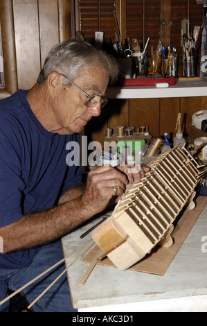 Elderly map working on ship model Stock Photo