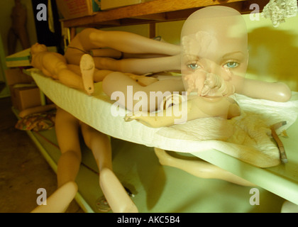 Manikin parts in the basement of a haunted museum Manikin head is double exposed to look ghostly Stock Photo