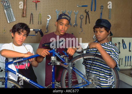 Multicultural teens age 15 at youth group community  bike shop. St Paul Minnesota USA Stock Photo